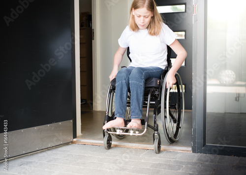Person in a wheelchair moving over a low doorstep