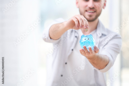 Young man putting coin into...