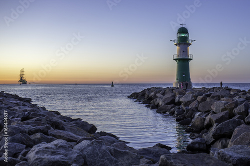 Kreuzfahrtschiff verlässt den Hafen von Warnemünde an der Ostsee im Sonnenuntergang