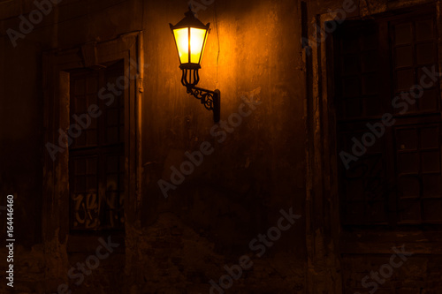 Old lantern illuminating a dark street