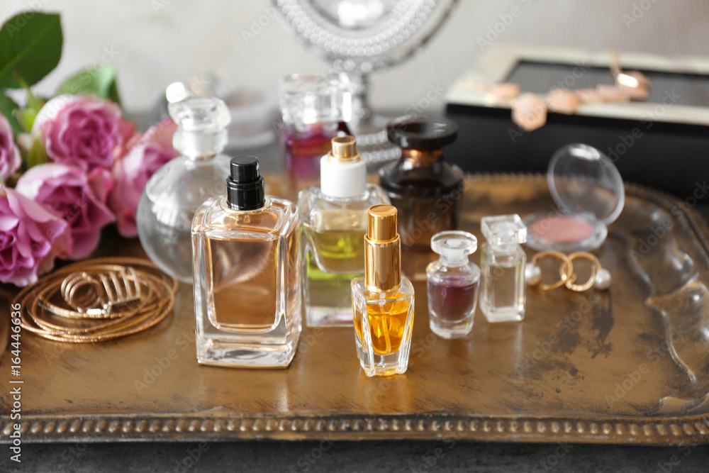 Metal tray with bottles of perfume on table Metal tray with bottles of perfume on table