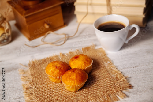 Muffins and coffee on a wooden table.