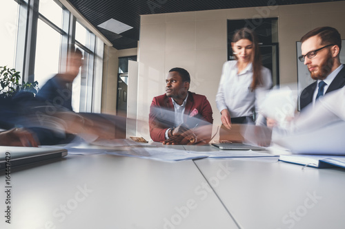 businesspeople working in office, one man think, pronounced motion blur
