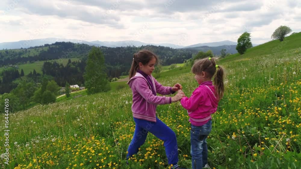Children playing on a flowering lawn against the backdrop of the Carpathian Mountains Children playing on a flowering lawn against the backdrop of the Carpathian Mountains