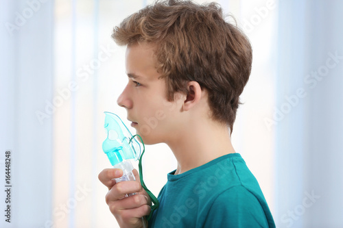 Young boy using nebulizer f...