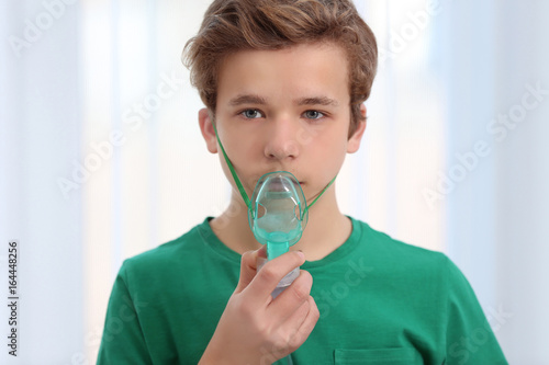 Young boy using nebulizer f...