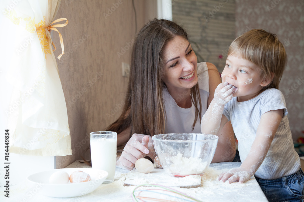 mother and young son prepare a cake in the kitchen