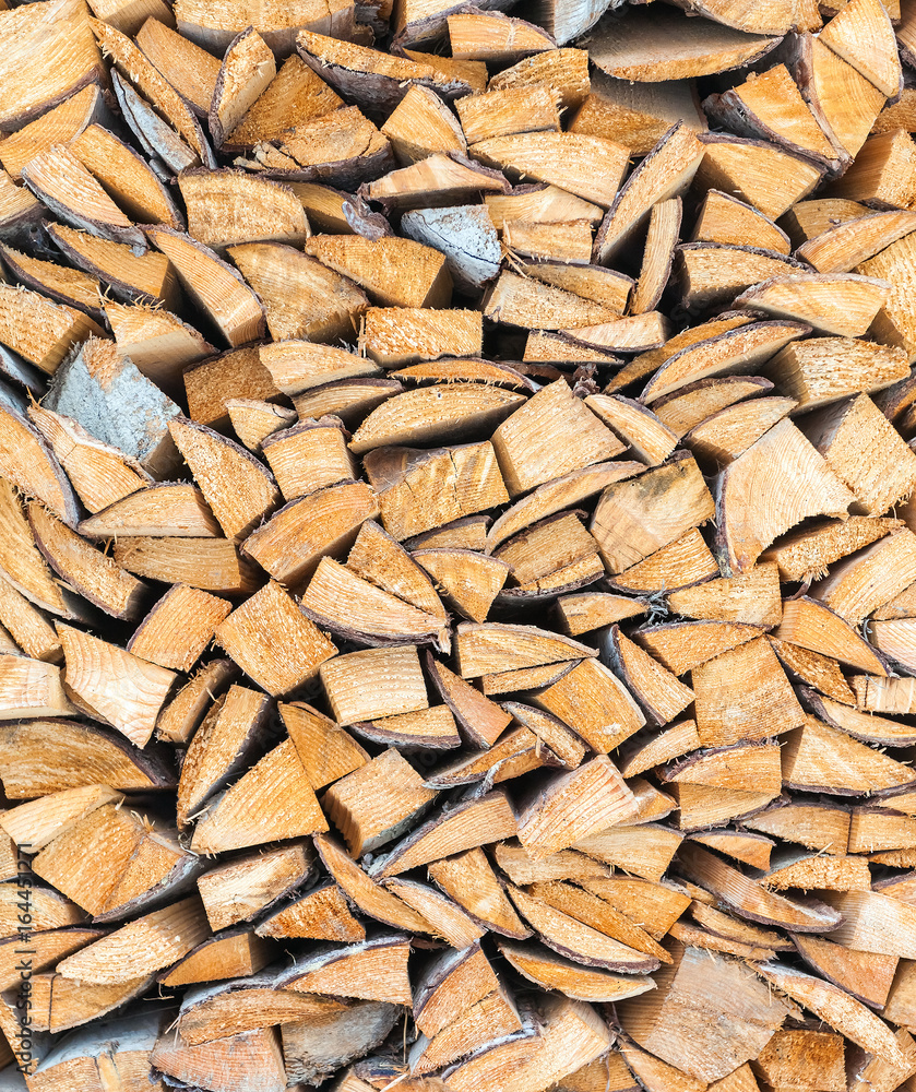Background of dry chopped firewood logs stacked up on top of each other in a pile in winter Background of dry chopped firewood logs stacked up on top of each other in a pile in winter