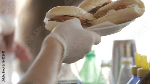 Cuoco sta servendo dei panini alla piastra in un lido per vacanze estive photo