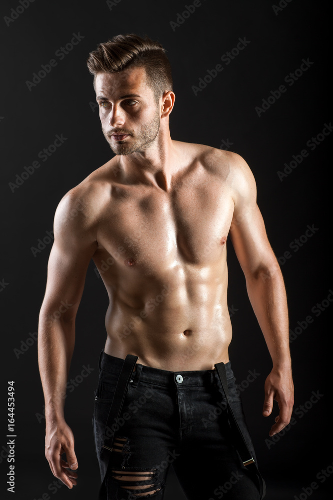 Portrait of a sexy muscular shirtless man on dark background Portrait of a sexy muscular shirtless man on dark background