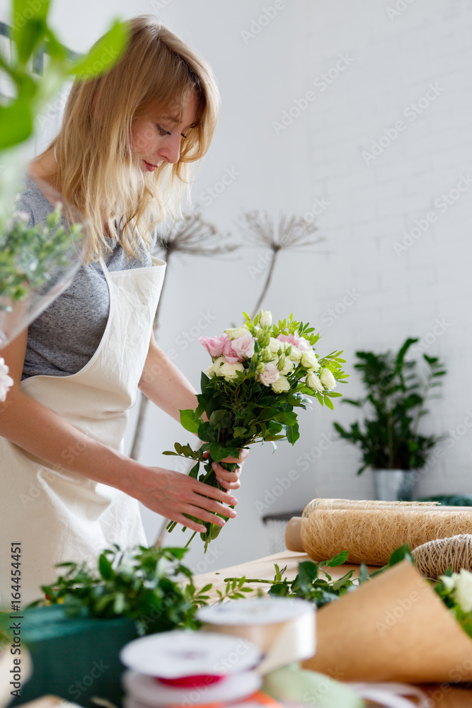 Young blonde in flower shop
