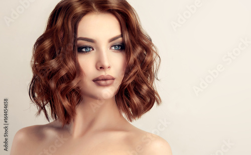 Beautiful model girl with short hair .Woman with red curly hair. Red head .
