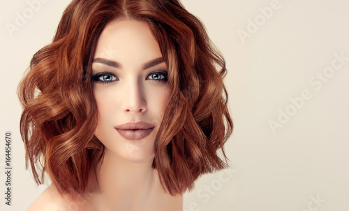 Beautiful model girl with short hair .Woman with red curly hair. Red head .
