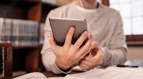 Photography College student using tablet pc in library