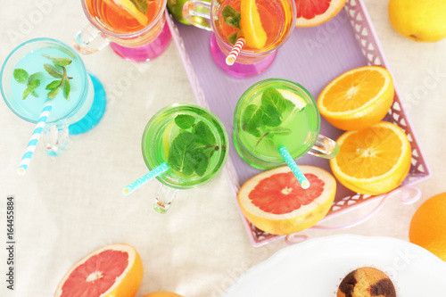 Glasses with different kinds of lemonade on table
