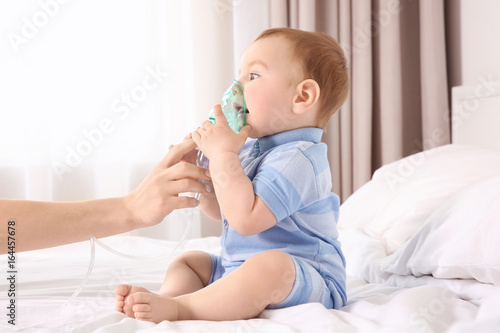 Mother helping her cute lit...