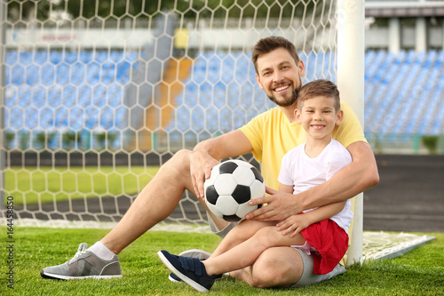 Dad and son with soccer ball in stadium © Africa Studio