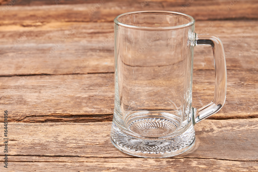 Empty glass mug, wooden table. Transparent glass for beer on wooden retro board. Empty glass mug, wooden table. Transparent glass for beer on wooden retro board.
