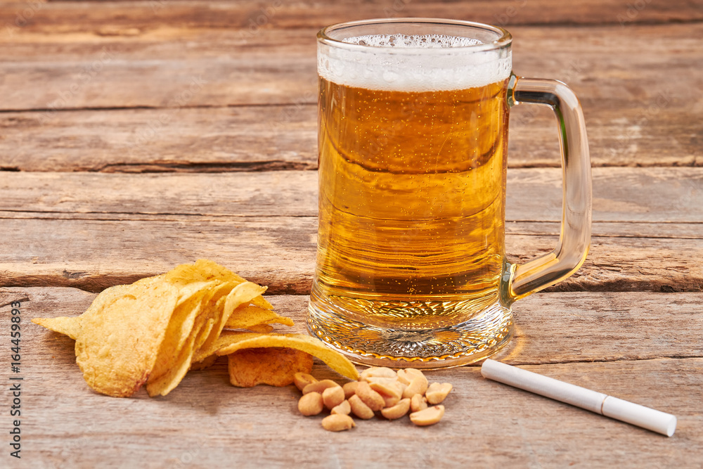 Foto de Glass of beer, chips, nuts, cigarette. Concept of beer