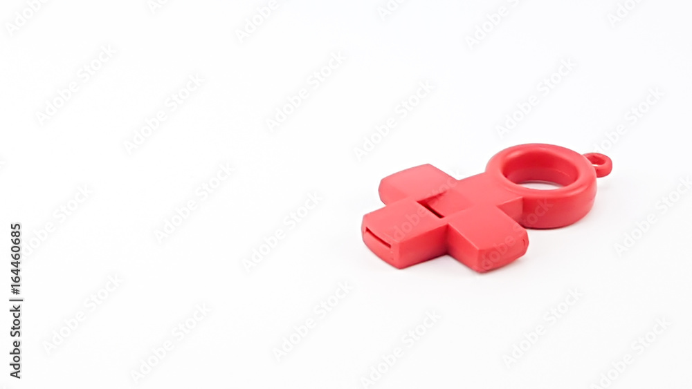 The red cross whistle is placed on the white background The red cross whistle is placed on the white background