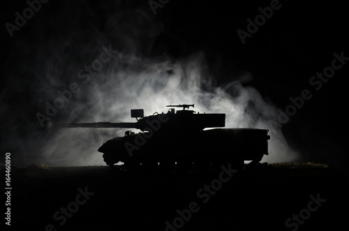 War Concept. Military silhouettes fighting scene on war fog sky background, German tank in action Below Cloudy Skyline At night. Attack scene. Armored vehicles