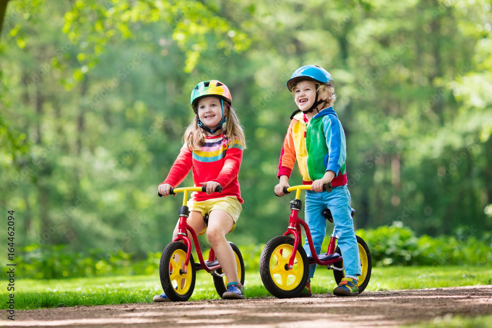 Fototapeta premium Kids ride balance bike in park