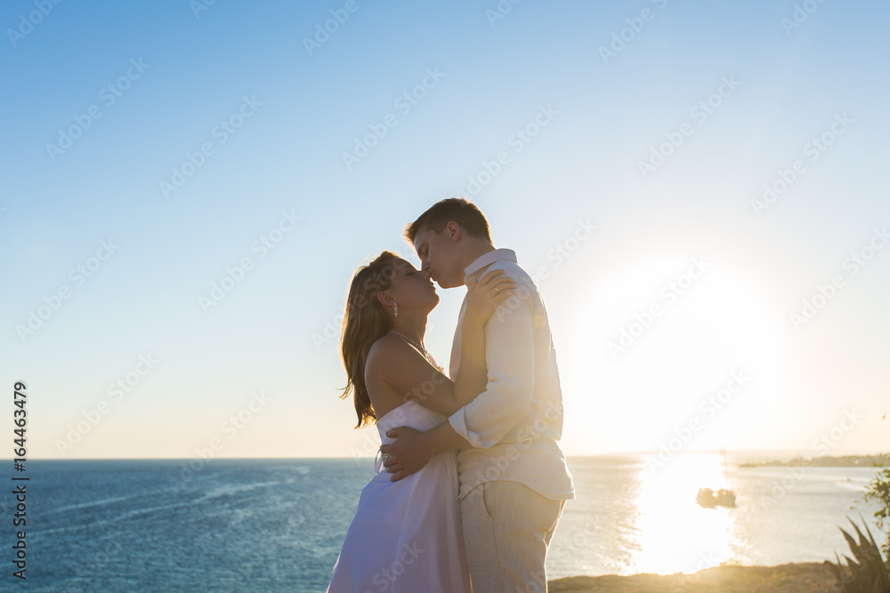 Couple embracing and kissing each other on the beach against ocean