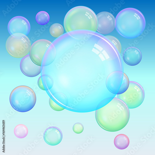 Colorful background of realistic transparent colorful soap bubbles with a rainbow reflection on a blue background