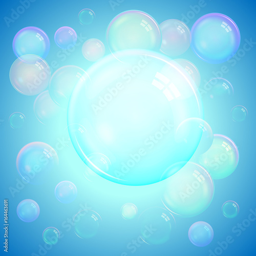 Colorful cool background of realistic transparent colorful soap bubbles with a rainbow reflection on a luminous blue background