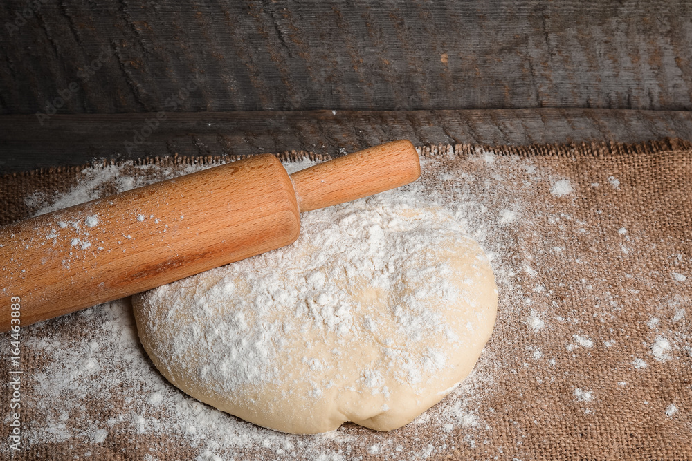 Ball of dough and rolling pin on rustic background Ball of dough and rolling pin on rustic background