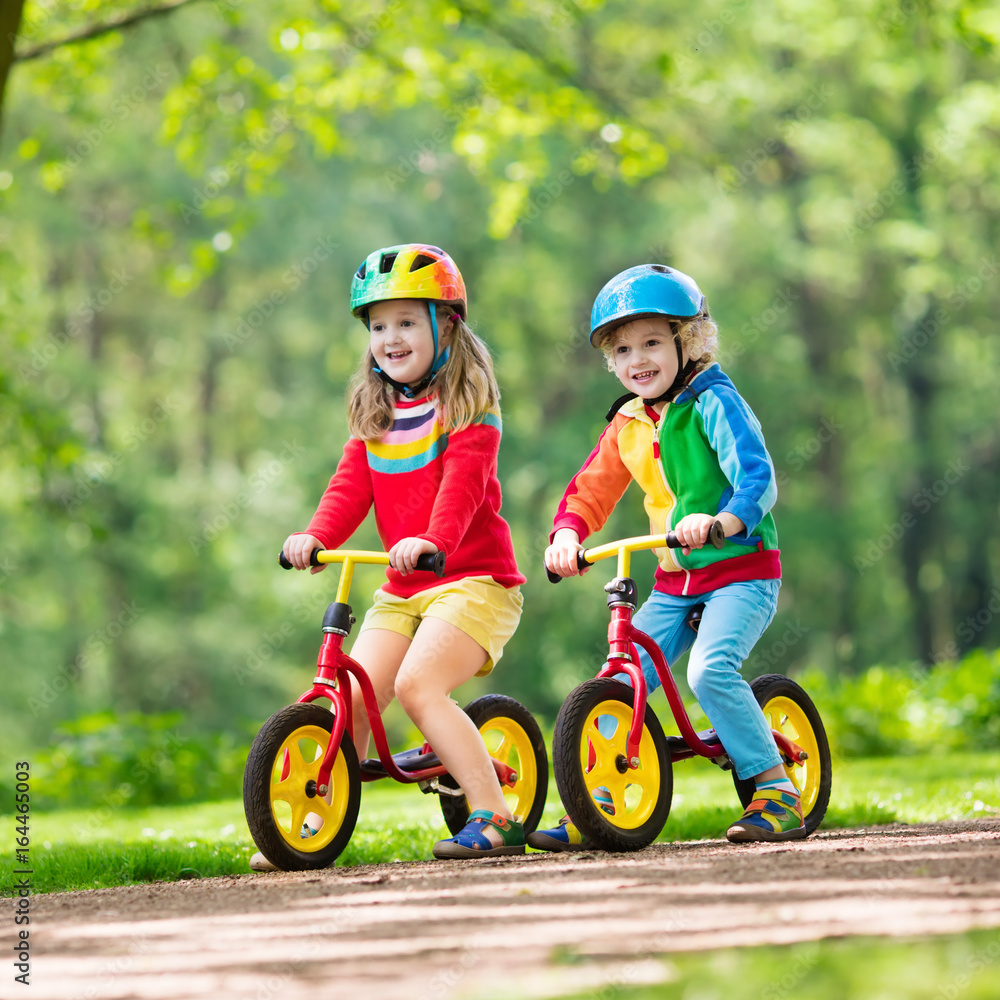 Fototapeta premium Kids ride balance bike in park