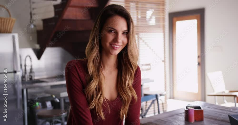 Portrait of attractive female millennial sitting inside kitchen, smiling at camera. Casual portrait of young Caucasian woman inside home, laughing. 4k Portrait of attractive female millennial sitting inside kitchen, smiling at camera. Casual portrait of young Caucasian woman inside home, laughing. 4k