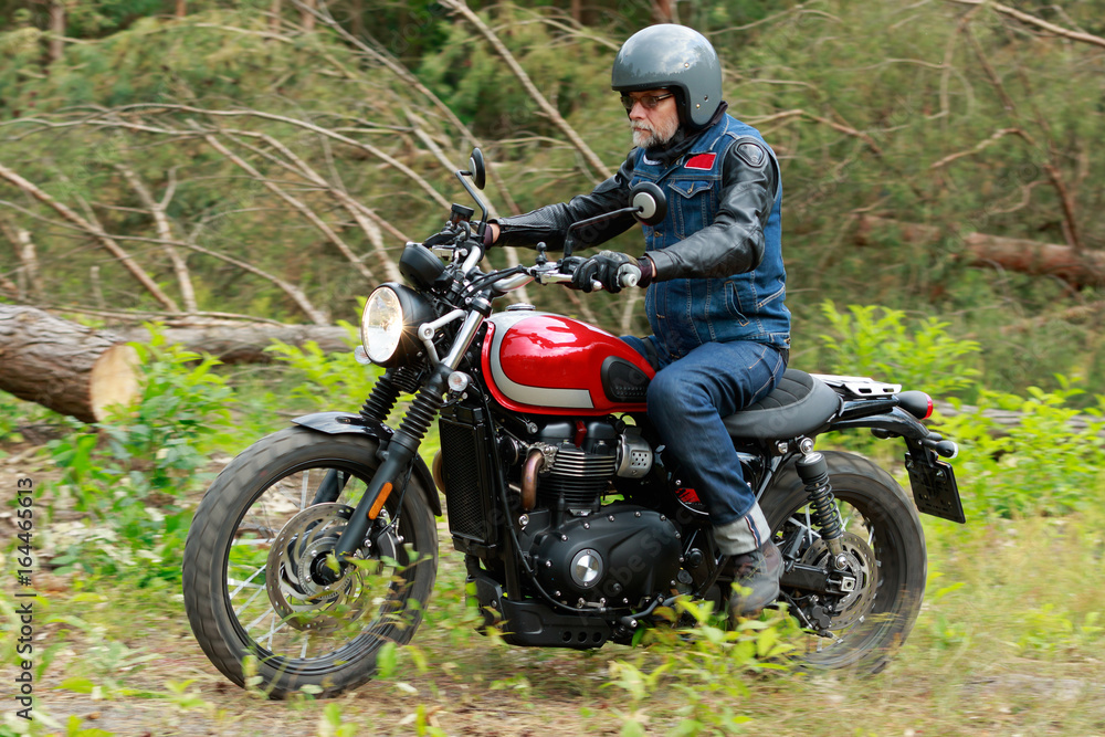 Man in grey helmet riding the red motorcycle in the forest Man in grey helmet riding the red motorcycle in the forest