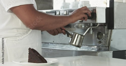 barista prepare milk with cffee machine in backround photo