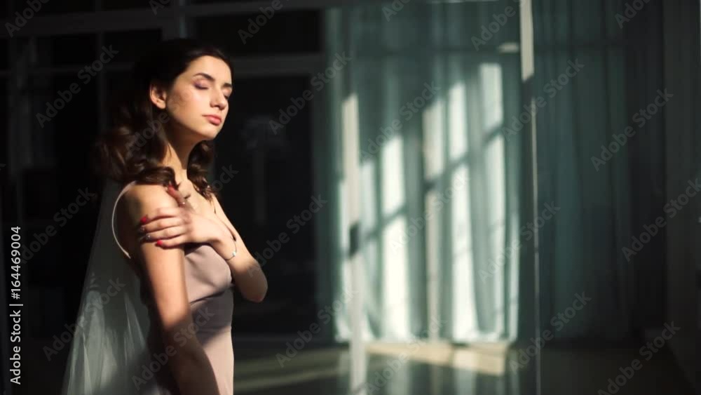 Model of the bride is basking in the rays of the sun emanating from the window. Model of the bride is basking in the rays of the sun emanating from the window.