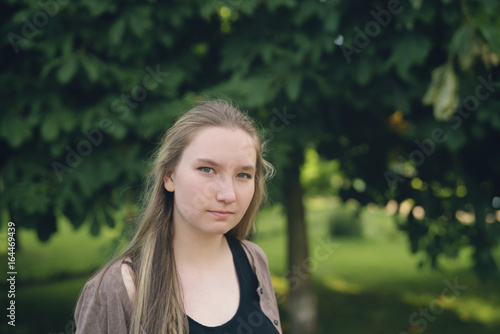 teen girl in green park in summer evening