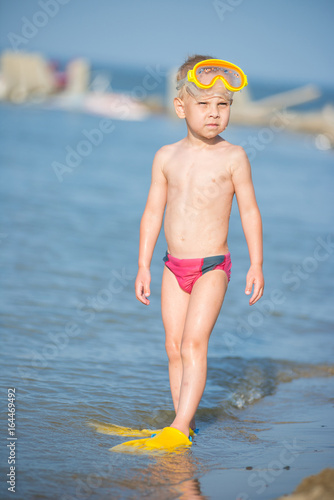 Little boy with snorkel by the sea. Cute little kid wearing mask and flippers for diving at sand tropical beach. Ocean coast.