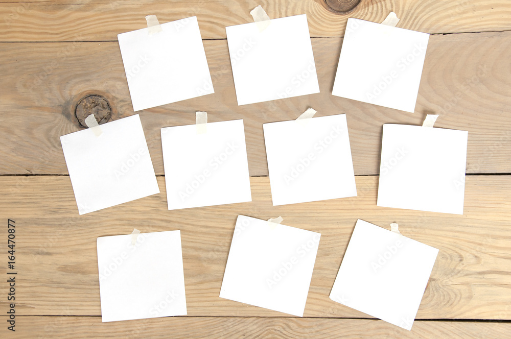 Many square paper stickers on a wooden surface. Many square paper stickers on a wooden surface.