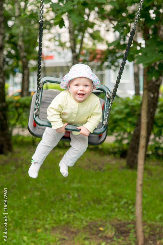 The baby is swinging on the swing