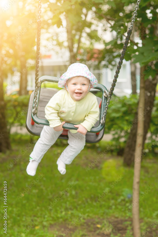 The baby is swinging on the swing
