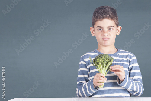 Little boy grimacing refusing to eat his broccoli