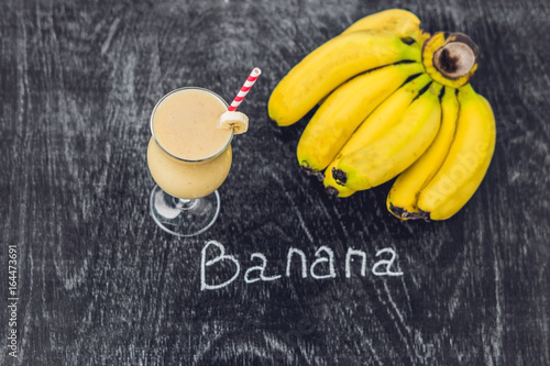 Banana smoothies and bananas on an old wooden background photo