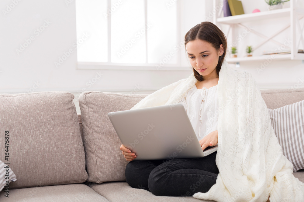 Cozy home. Girl in a plaid with a laptop Cozy home. Girl in a plaid with a laptop