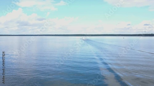 Aerial view on a couple driving a jet-ski at sea. Jet-ski at sea and the distant forest aerial photo