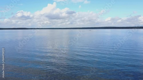 Morning on the calm lake with the reflection of the clouds and coastline in the water. Beautiful lake ladscape. Peacefull lake viev ladscape photo