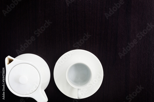 empty white coffee cup with jar on black wooden background.