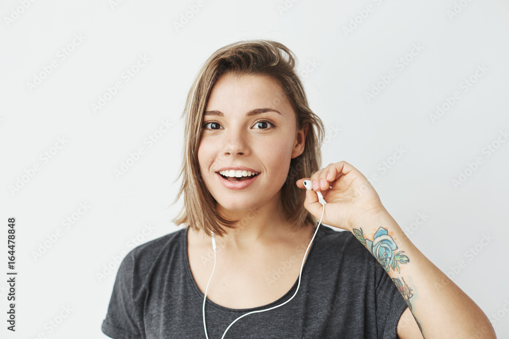 Nice young girl in headphones smiling looking at camera over white background. Nice young girl in headphones smiling looking at camera over white background.