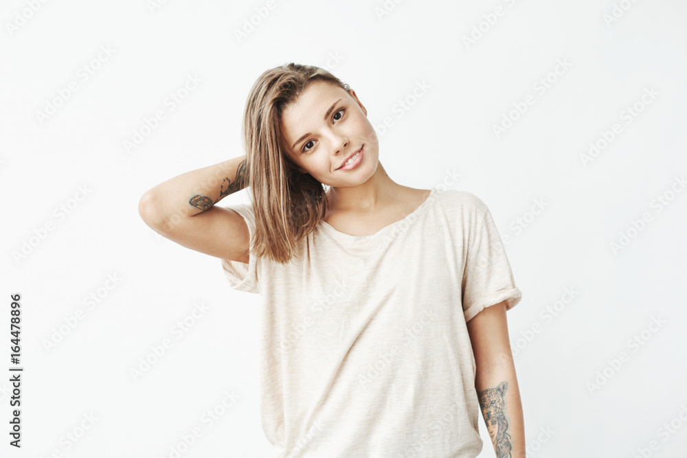 Portrait of young beautiful tattooed girl smiling posing looking at camera over white background. Portrait of young beautiful tattooed girl smiling posing looking at camera over white background.