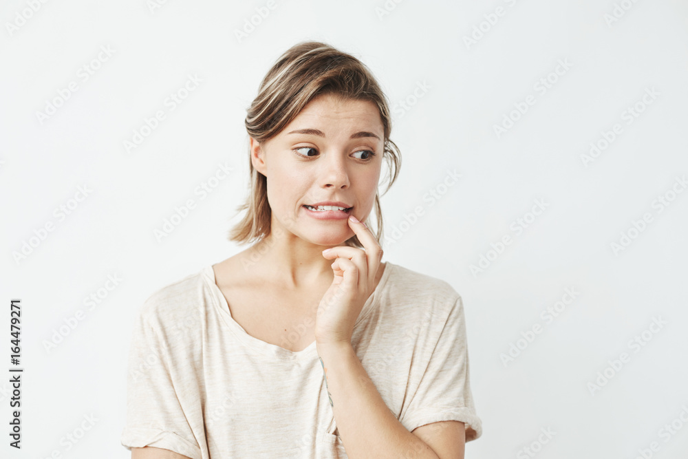 Young beautiful girl ashamed looking in side over white background. Young beautiful girl ashamed looking in side over white background.