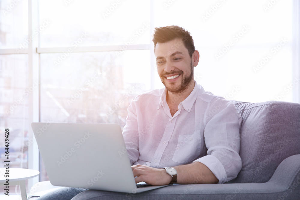 Handsome young man with laptop at home Handsome young man with laptop at home
